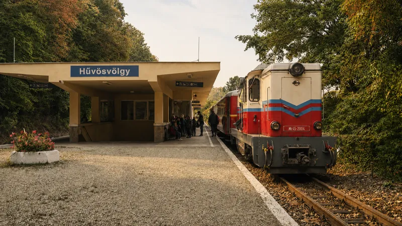 El tren de los niños de Budapest visto por fuera, junto al letrero de la estación de Hűvösvölgy